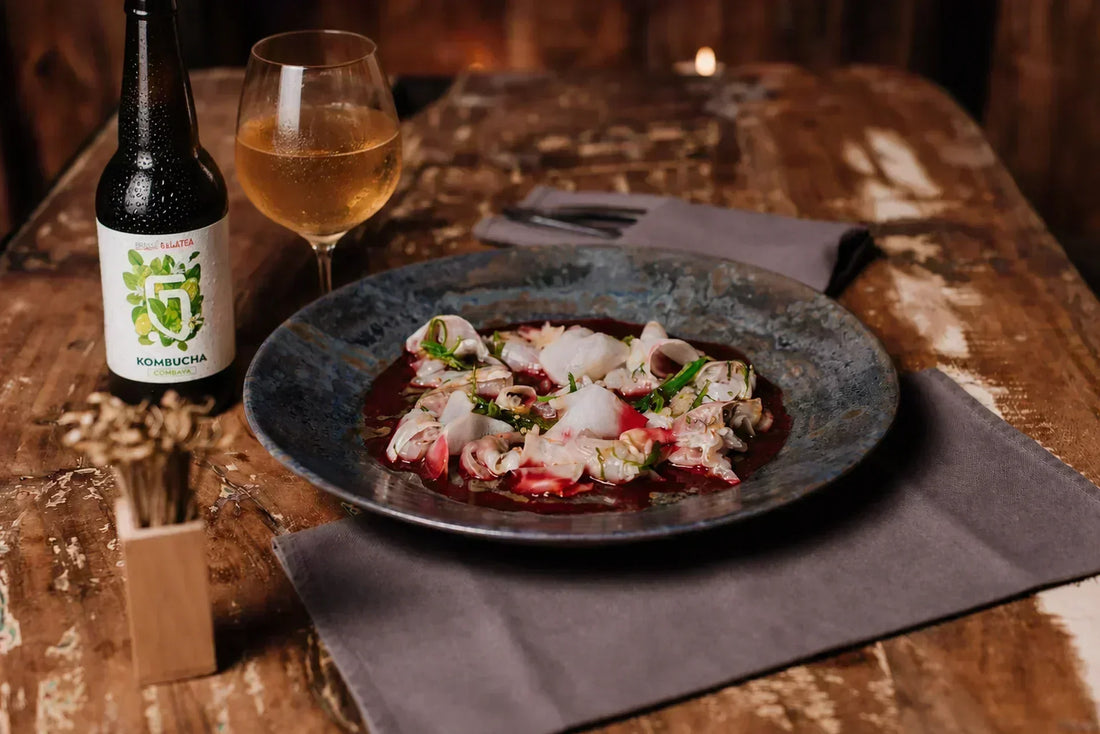 Accord kombucha Combava et ceviche de poisson cru, servi en verre à pied