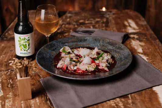 Accord kombucha Combava et ceviche de poisson cru, servi en verre à pied
